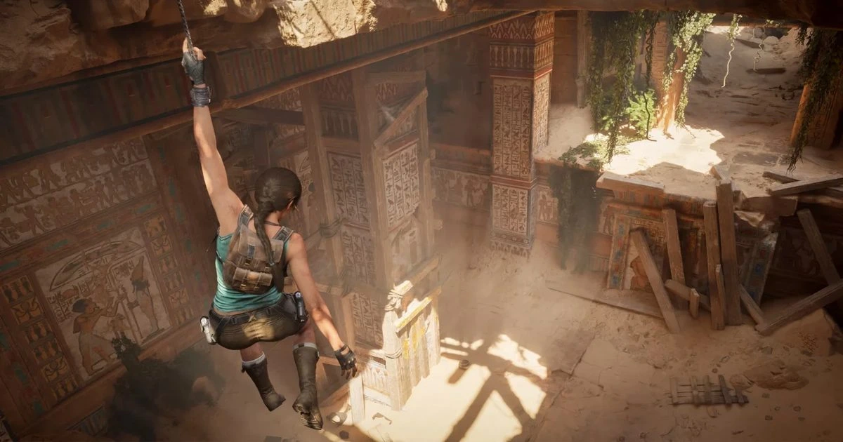 Lara Croft, harabe bir yapının içinde ipten sarkarak ilerliyor.