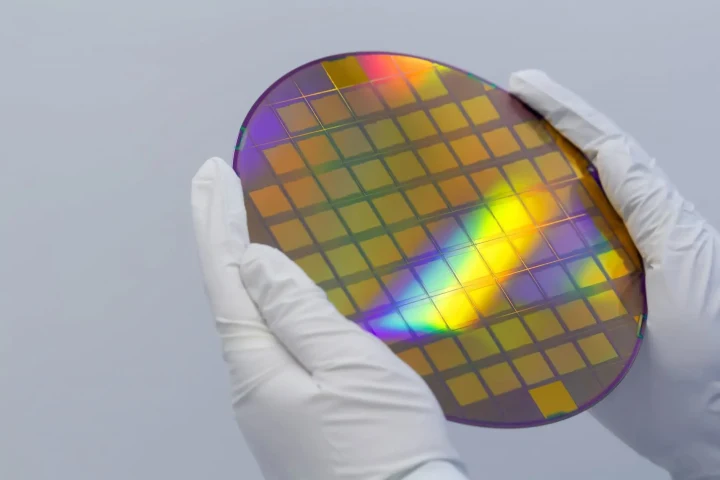 Eldivenli ellerin tuttuğu, üzerinde yonga kalıpları bulunan renkli silikon wafer