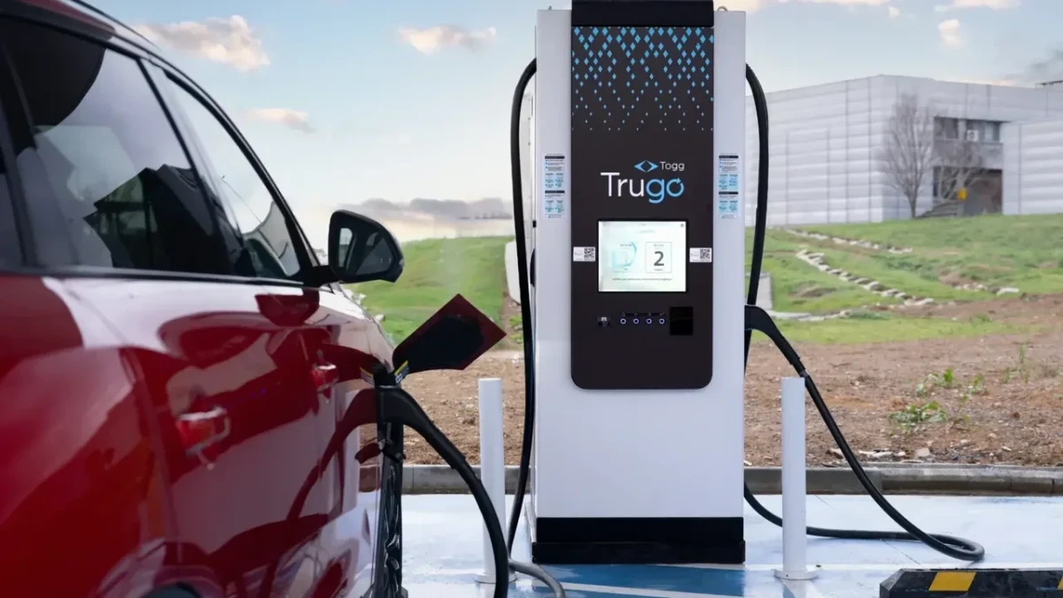 Kırmızı bir elektrikli araç, Trugo hızlı şarj ünitesinde şarj ediliyor.