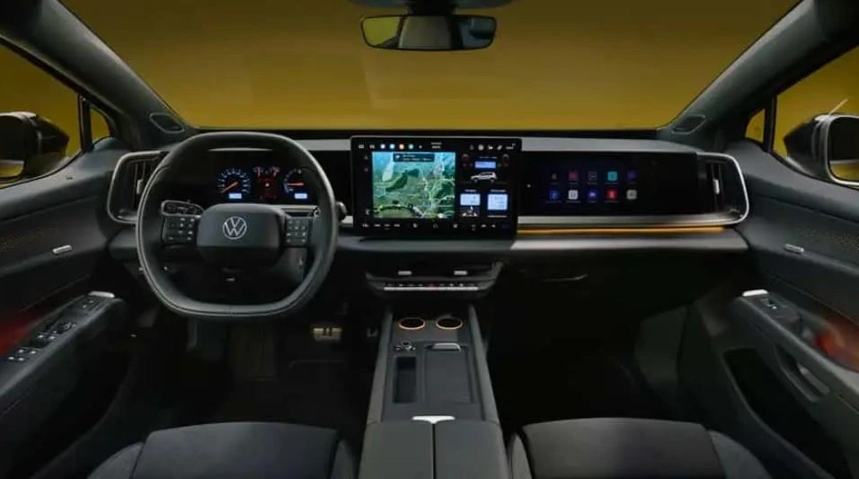 Volkswagen otomobilinin kokpitinde direksiyon, dijital gösterge paneli ve geniş multimedya ekranı