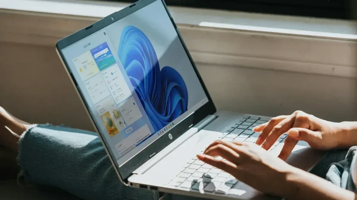 Windows 11 ekranı açık dizüstü bilgisayarda çalışan kullanıcı