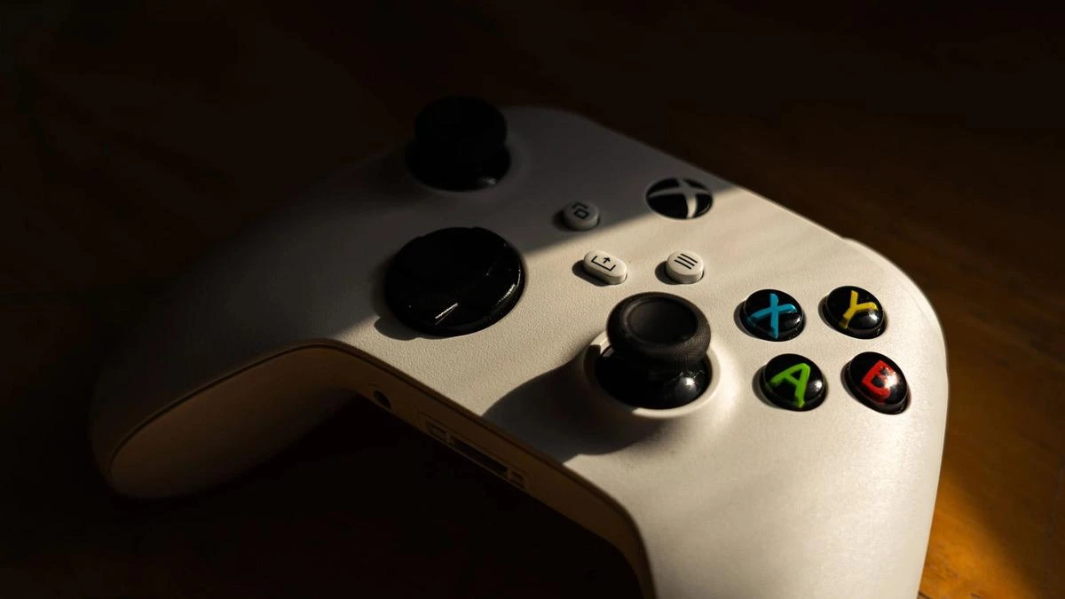 Ahşap yüzey üzerinde beyaz Xbox oyun kumandası