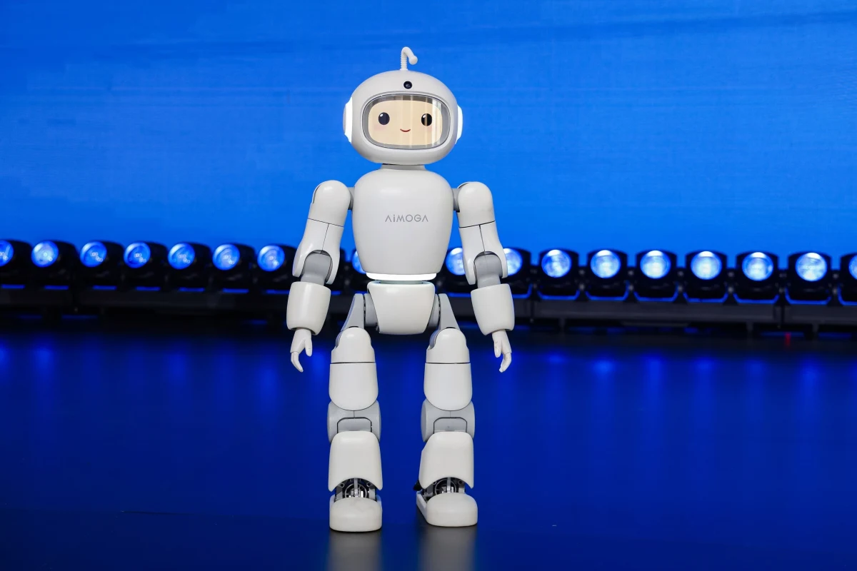 Mavi ışıklarla aydınlatılmış sahnede duran küçük beyaz insansı robot
